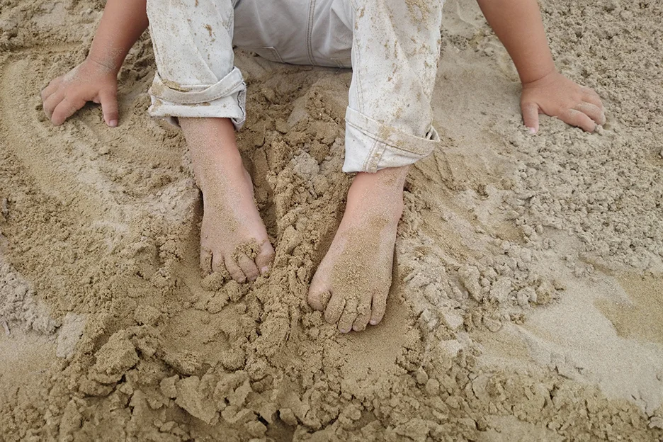 Kinderfüße wühlen im Sand